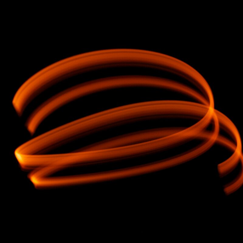 Oranje lichtspoor draait op een zwarte achtergrond voor het samenwerken van WordPress met andere tools.