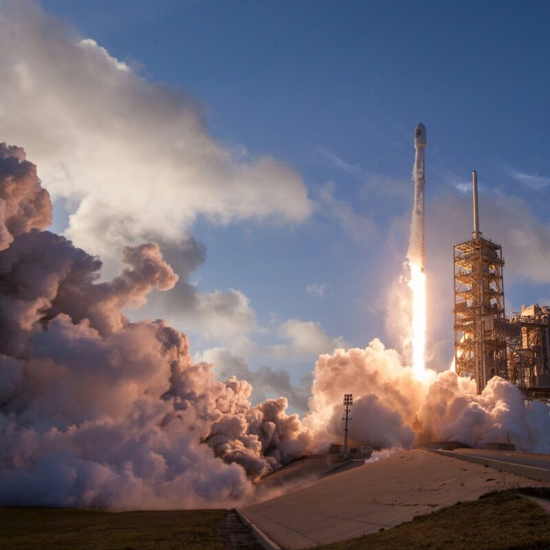 Een raket neemt vanaf een lanceerplatform de start in een wolk van rook en vuur. Deze afbeelding illustreert de energie en snelheid van een vlakbij lanceerde