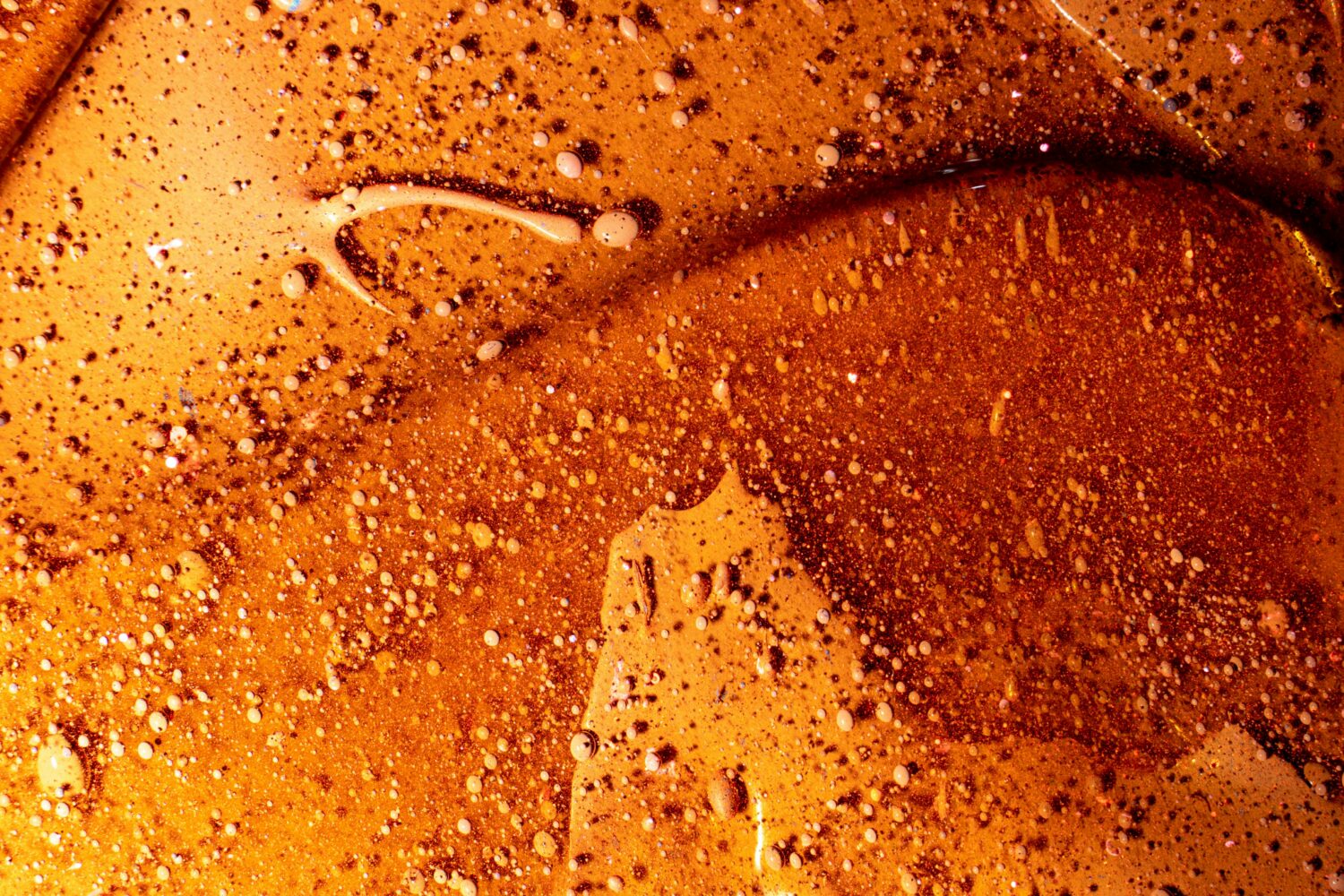Close-up van een glad oppervlak met kleine bubbeltjes en een donkerbruine tint, illustrerend het WordPress 7.0 update artikel.