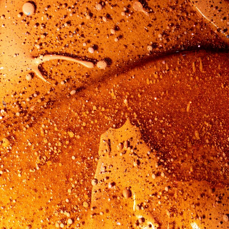 Close-up van een glad oppervlak met kleine bubbeltjes en een donkerbruine tint, illustrerend het WordPress 7.0 update artikel.